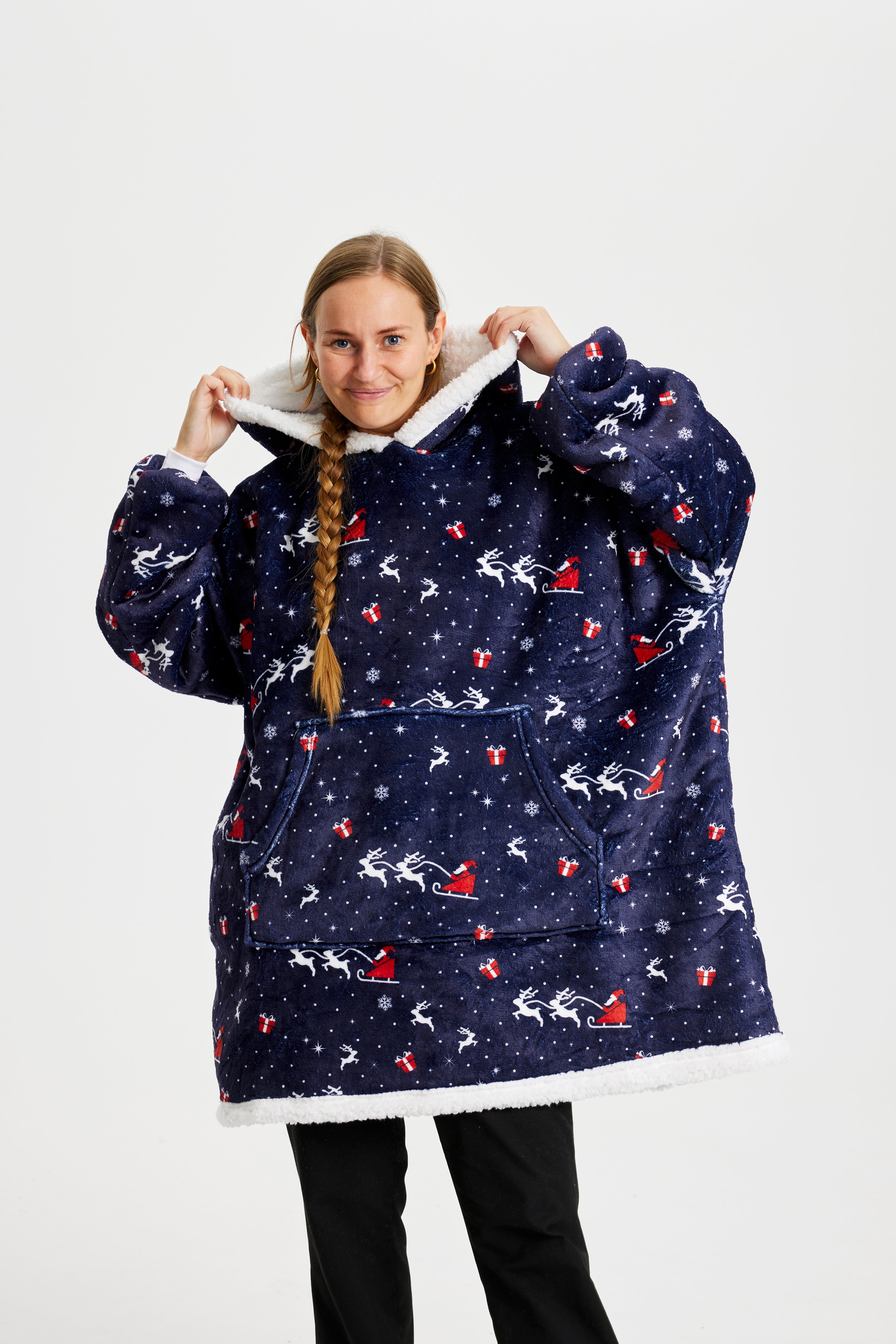 Eine Frau, die einen blauen gemusterten Weihnachts-Kapuzenpullover trägt.